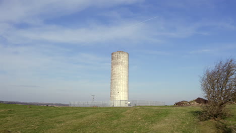 establishing tracking shot of a large water tower, bathed in pleasant morning light