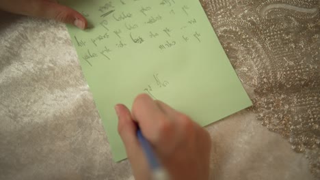 A-jewish-12-year-old-boy-is-sitting-by-a-table-and-writing,-pov-shot