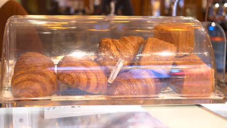 freshly baked croissants in a bakery display case