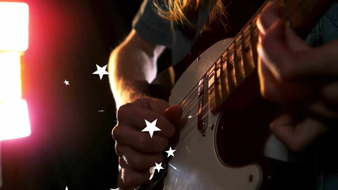 Gitarist elektro gitar çalıyor, köprüye yakın tellere vuruyor ve müzik için animasyonlu yıldızlar oluşturuyor.