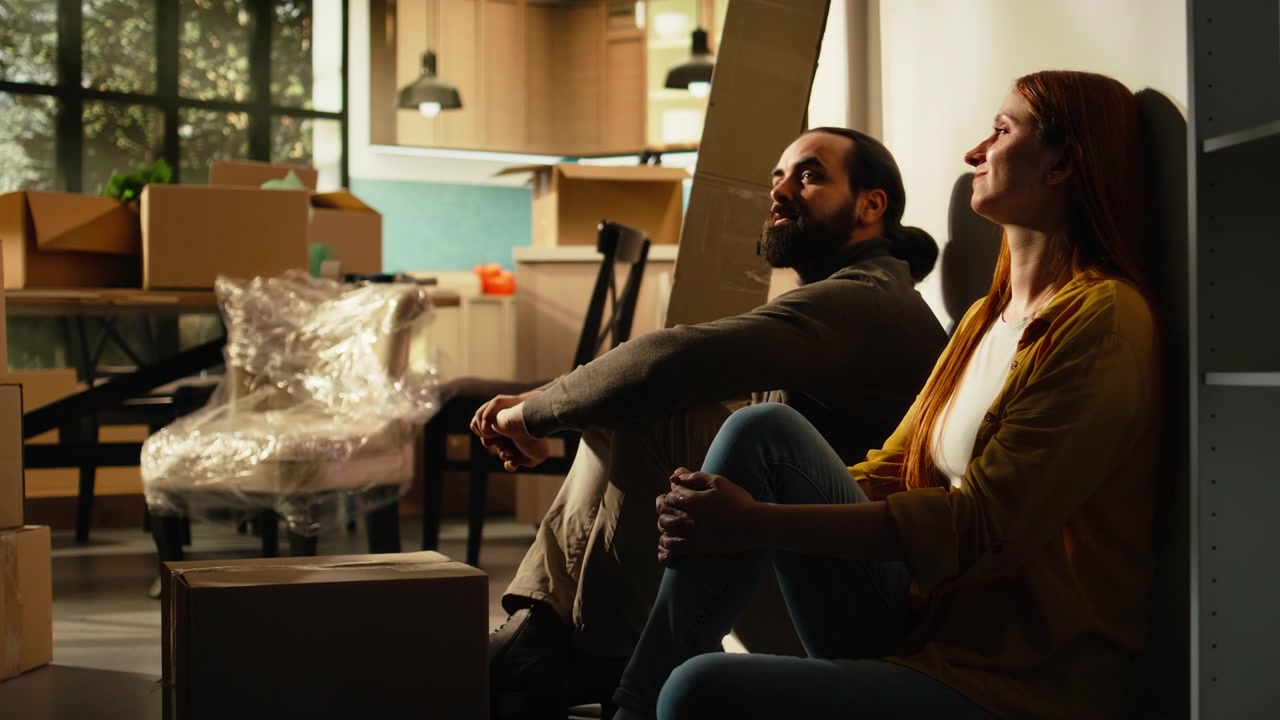 Couple Resting on Floor After Moving Into New Home