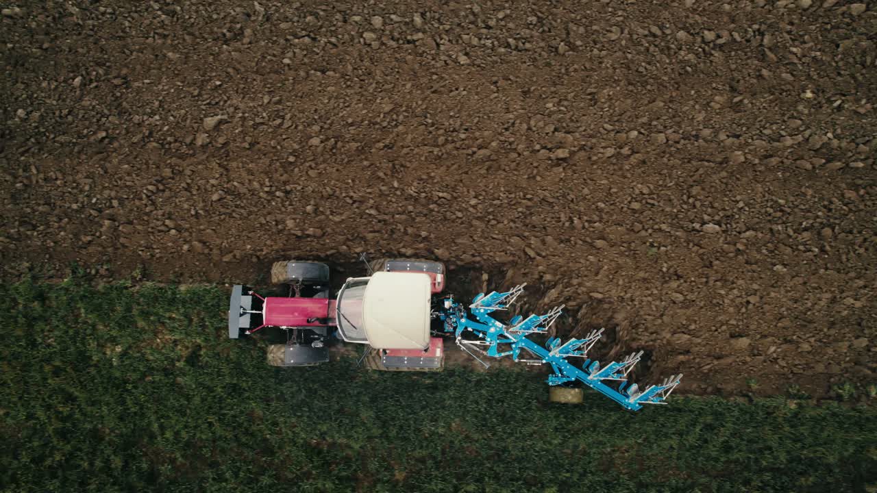 un tractor arando un campo, con una vista clara del suelo recién girado, vista aérea