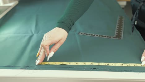 female tailor marking rough edge of fabric