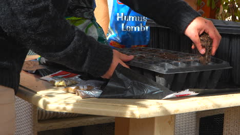 man putting soil into seedbeds to grow vegetables in the garden