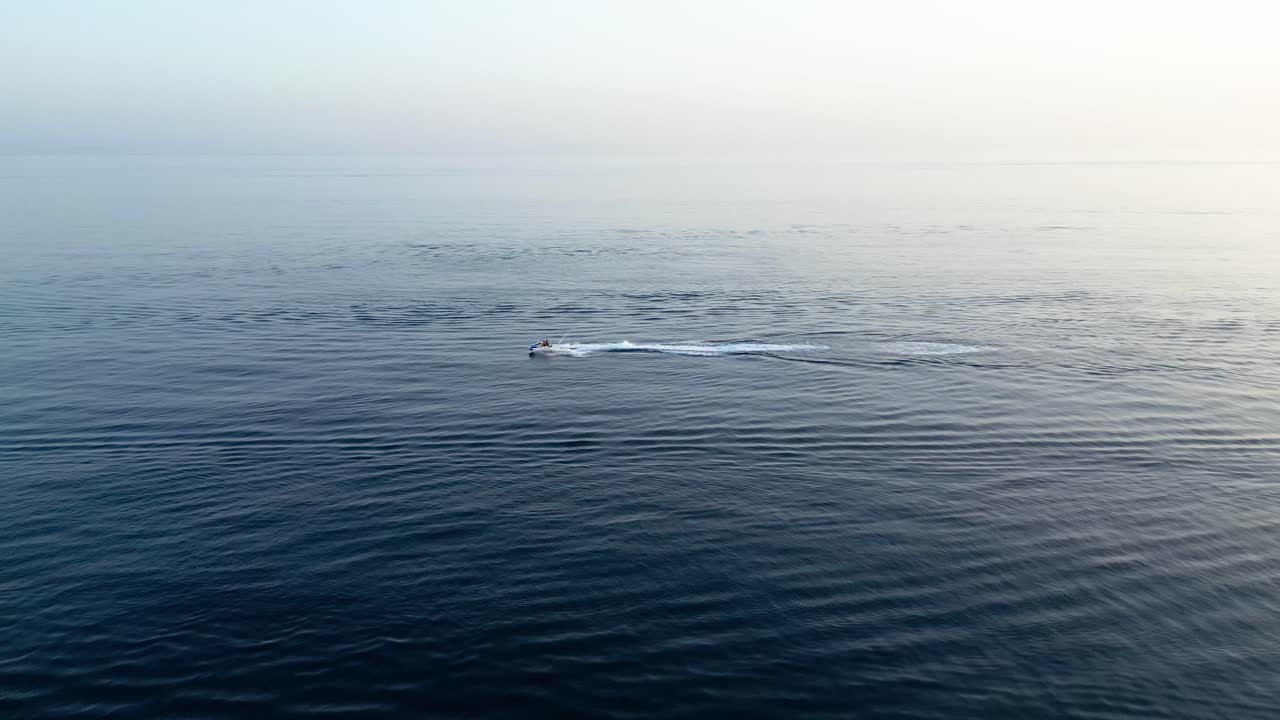 서서히 해가 지는 바다에서 제트 스키를 타고