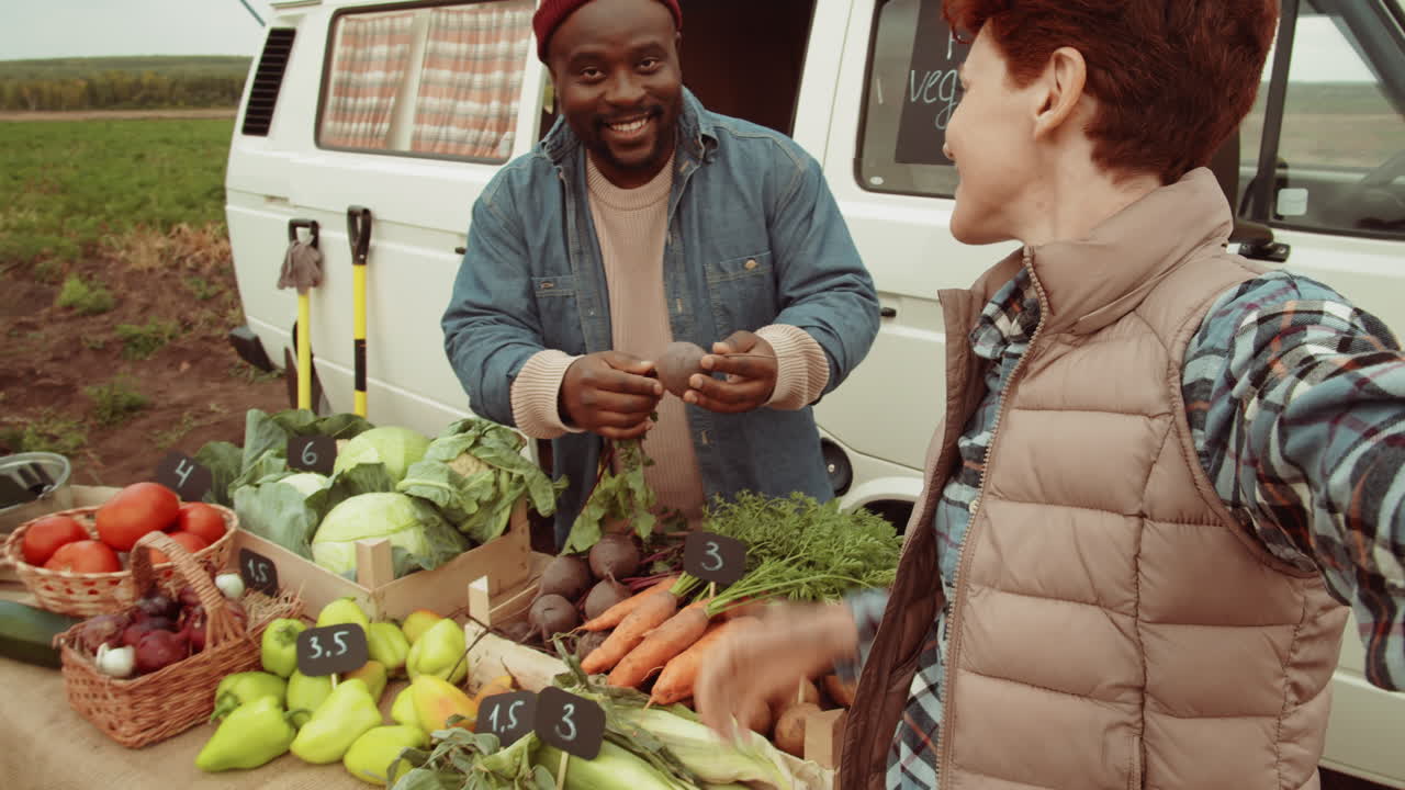 Maraîchers heureux parlant en visioconférence sur un marché de légumes en plein air