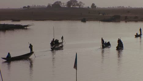 boats are rowed in silhouette on the niger river in mali africa