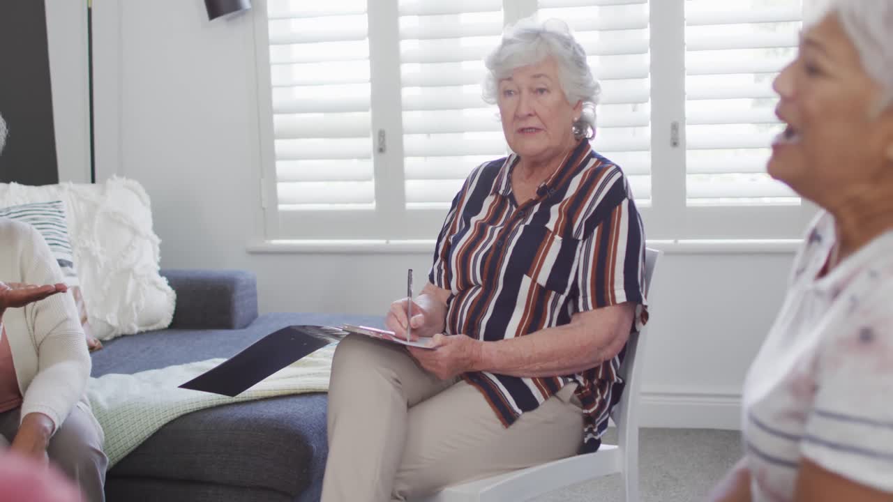 다양한 고령 친구 그룹에 조언하는 클립보드와 함께 caucacian 수석 여성 조언자