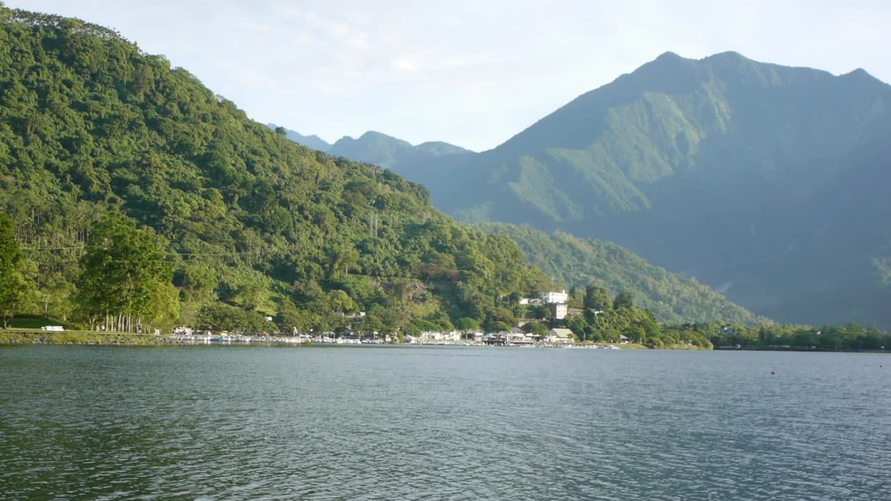 느린 팬으로 촬영된 산속에 숨겨진 느리고 고요한 호수의 물에 잔물결