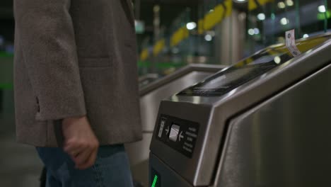persona que utiliza la puerta de billetes en una estación de tránsito