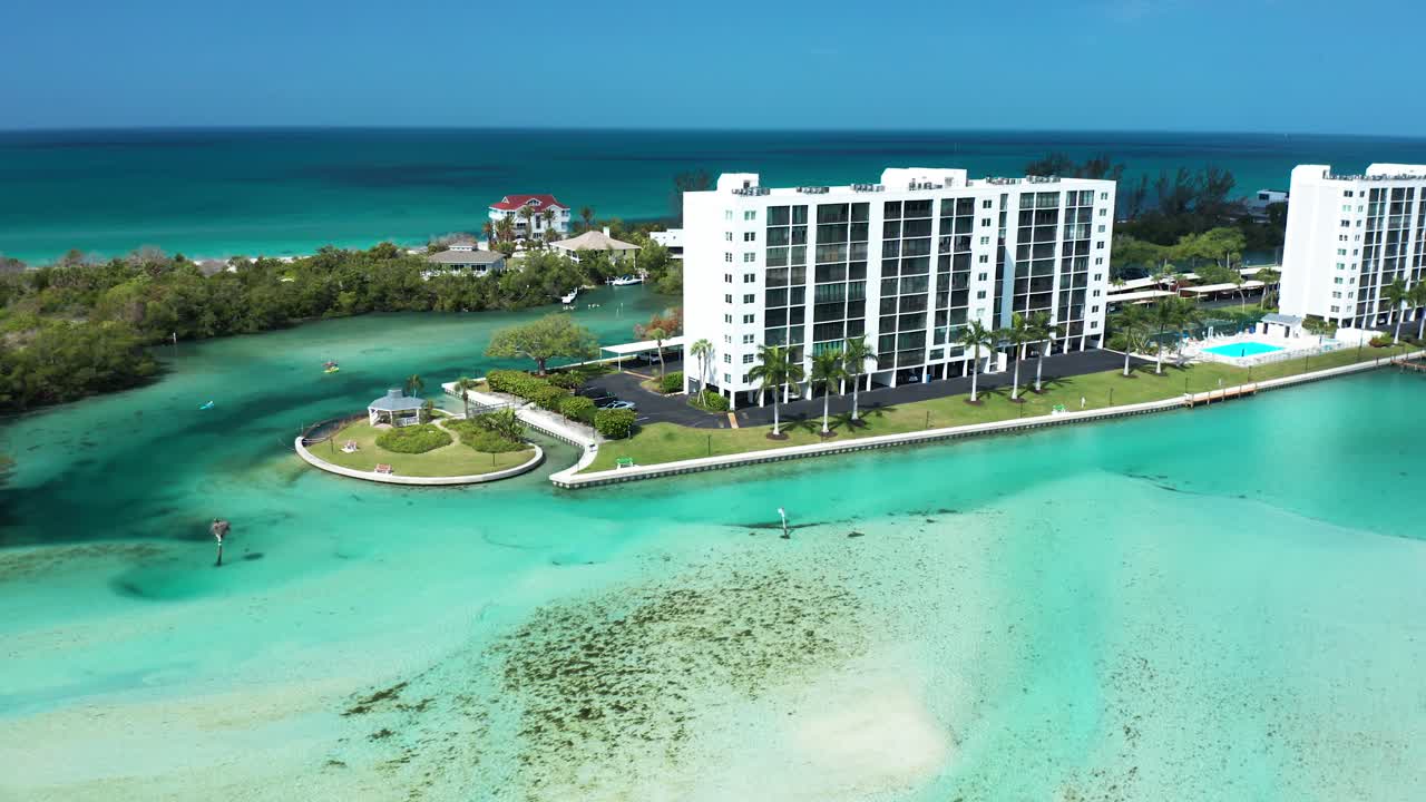 Un grattacielo accanto a un'insenatura color verde acqua e mangrovie. Perfetto per contenuti immobiliari o di viaggio