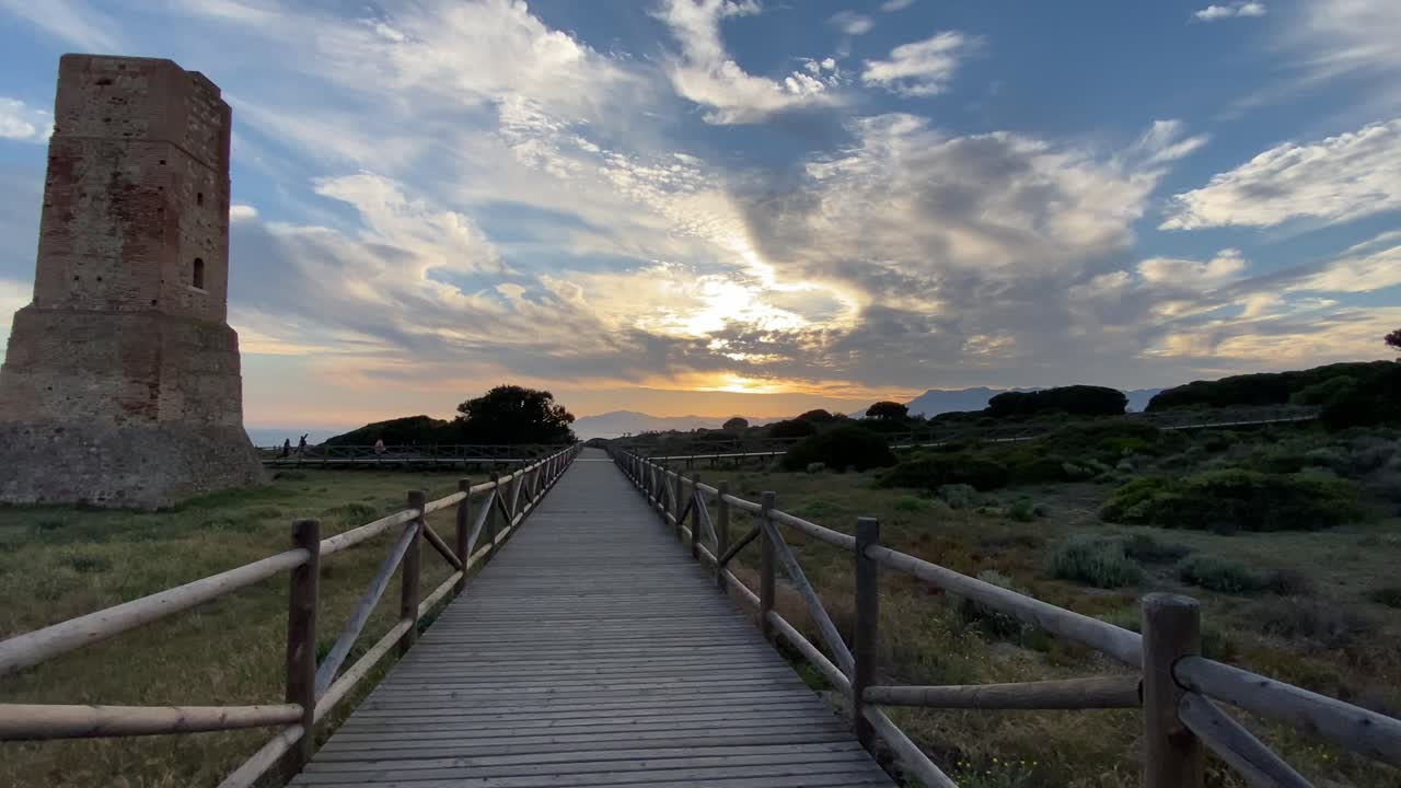 Walking on a wooden path on a southern Spanish beach in Marbella, with stormy skies.