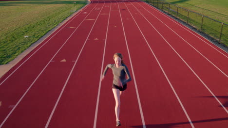 Teen-girl-runs-on-a-high-school-track-drone-camera-precedes