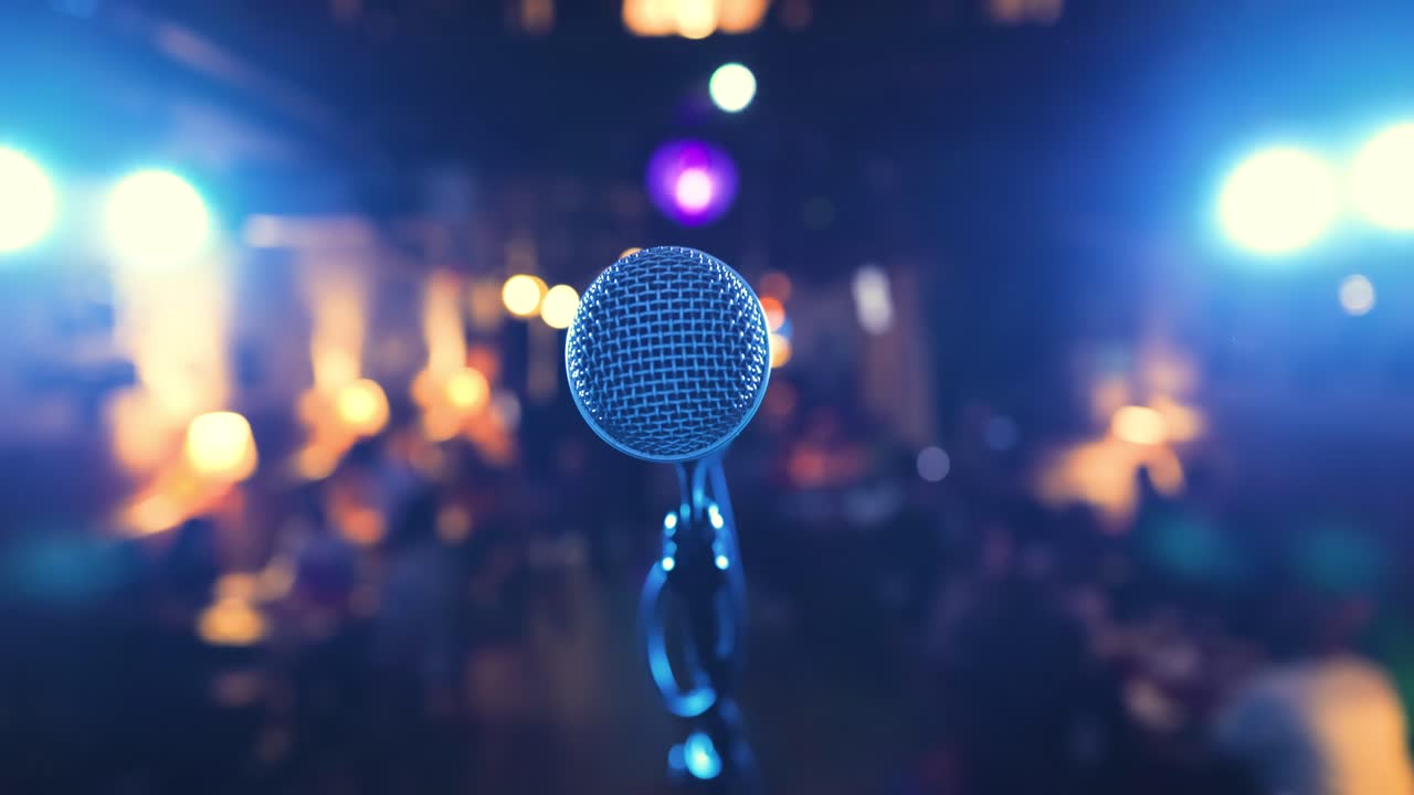 micrófono en el escenario contra un fondo de auditorio.