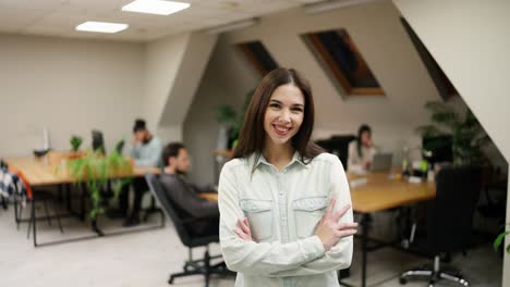 una chica caucásica sonriente de pie en un espacio de coworking de oficina moderno