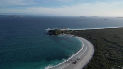 High-panoramic-aerial-footage-of-the-turquoise-water-and-white-sand-at-Wylie-Bay-Rock-Beach