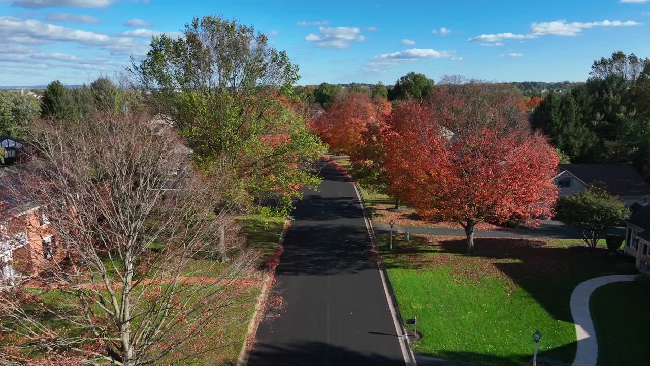 calle del vecindario alineada con colorido follaje de otoño en los árboles