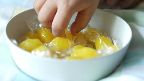 child reaching for candies in a bowl