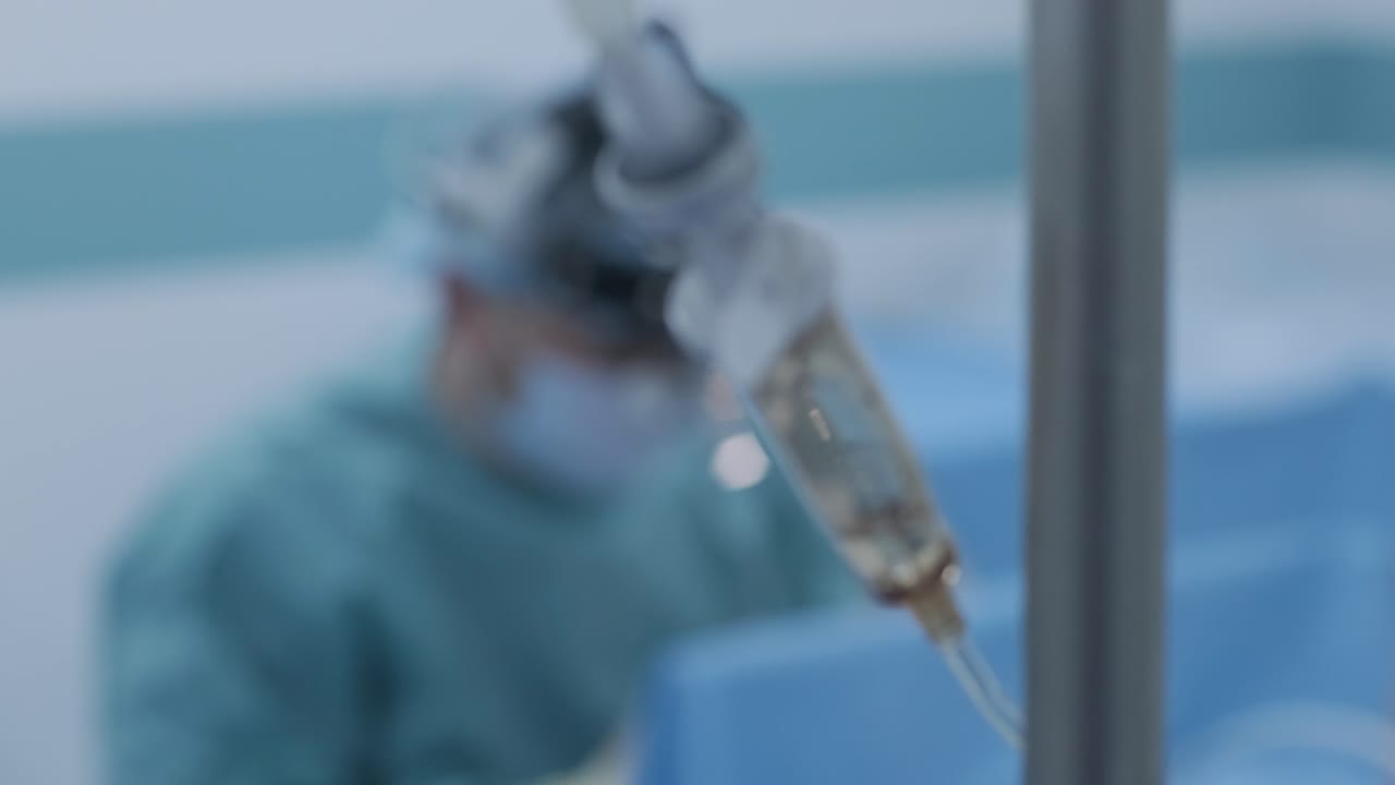 Operation of removing tonsils under deep anesthesia, surgeon uses latest devices, cold plasma method, cuts swelling in throat, doctor works with new probe, medical headlamp, surgical loupes