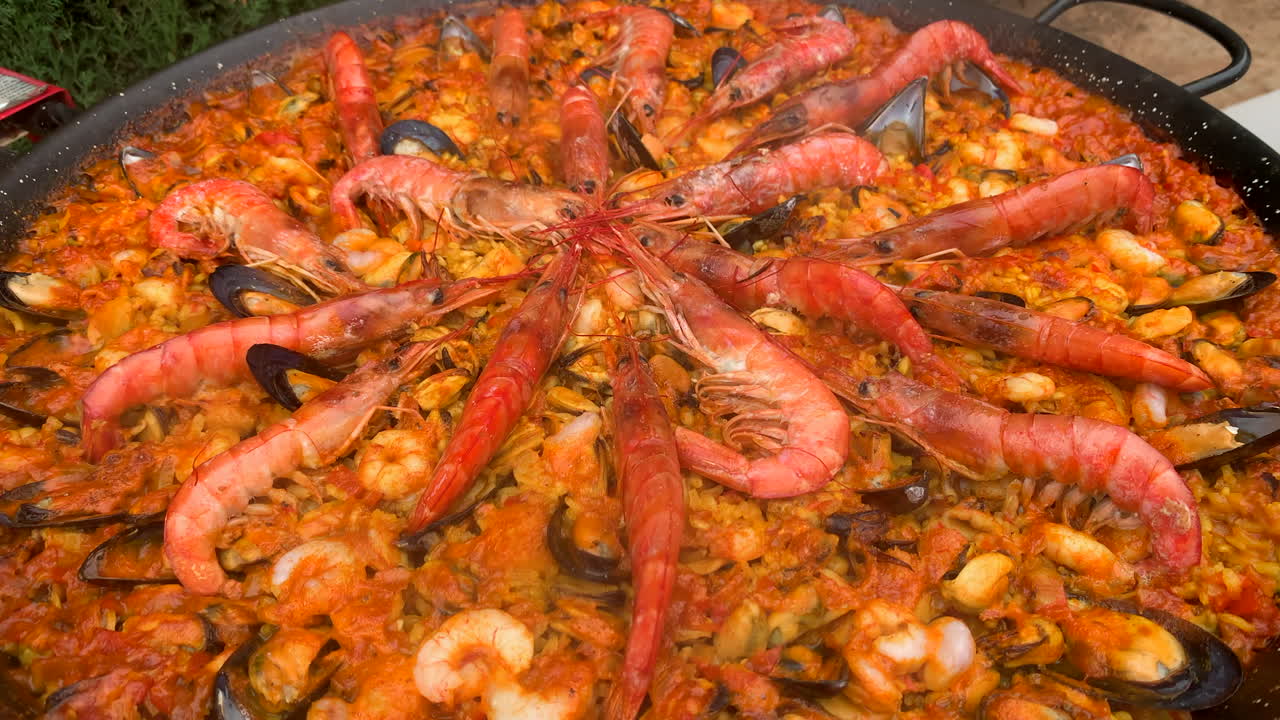 스페인의 전통적인 해산물 파엘라 (paella) 는 큰 판에 요리됩니다.