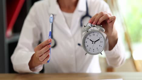 a healthcare professional holding a toothbrush and an alarm clock