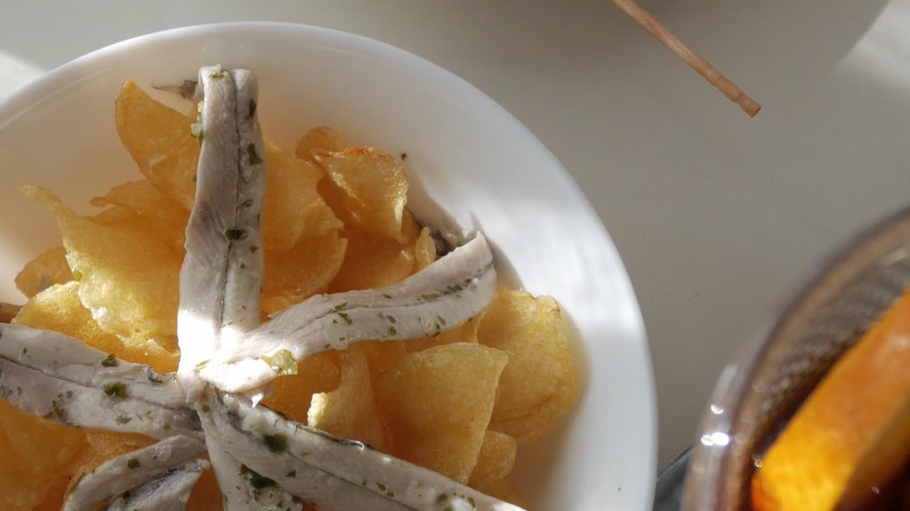 Tapas dish featuring Gildas, Boquerones, and crispy chips on a plate