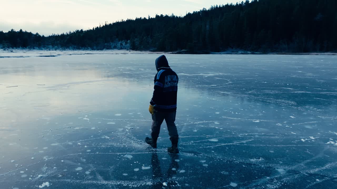 Indre Fosen, Trondelag County, Norway - A Man Strolling on the Frozen Surface of Omundvatnet as Dusk Settles in - Tracking Shot