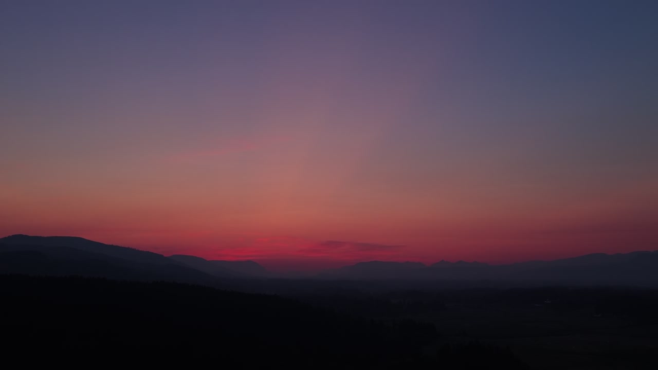 Vibrant Skies Over Silhouetted Mountain Range In Cowichan Valley on Vancouver Island, Canada. - aerial shot