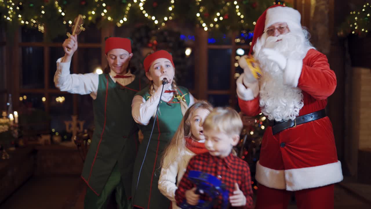 Happy children with Santa Claus. Christmas evening with Santa Claus and elves