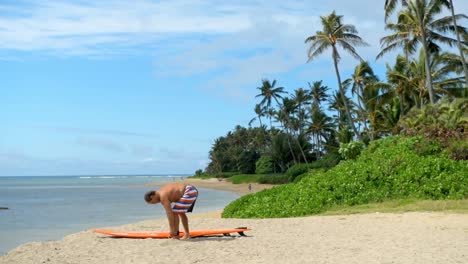 hombre de pie con tabla de surf en la playa 4k