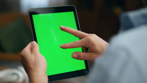 student fingers zooming greenscreen tablet at home. guy hands swiping computer