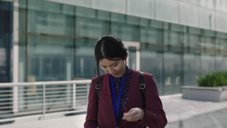 portrait of young asian woman puts in earphones listening to music intern student