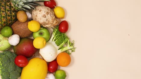 healthy composition of fresh and ripe fruits and vegetables move on the left side of the table with copy space. stop motion flat lay