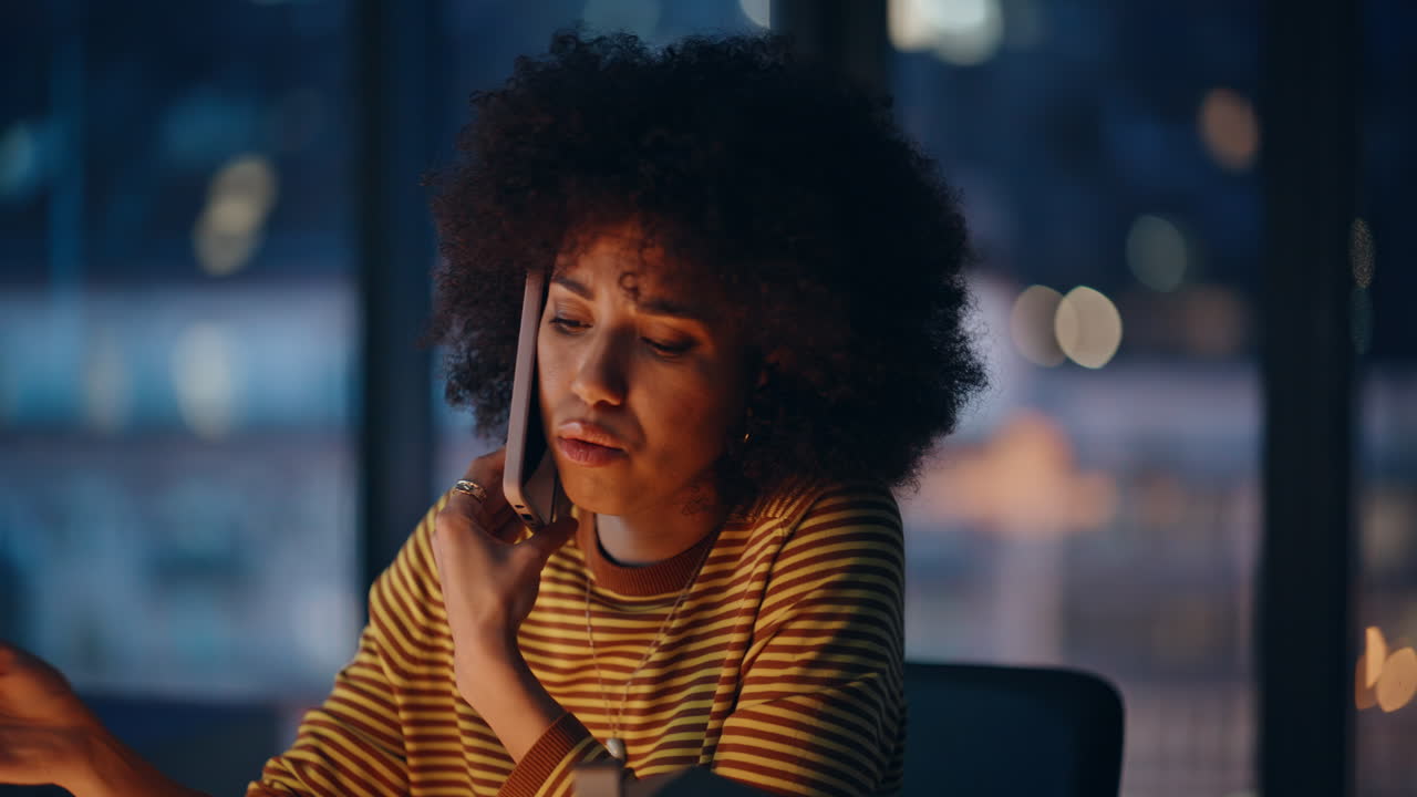 Stressed businesswoman speaking smartphone at evening corporate office closeup