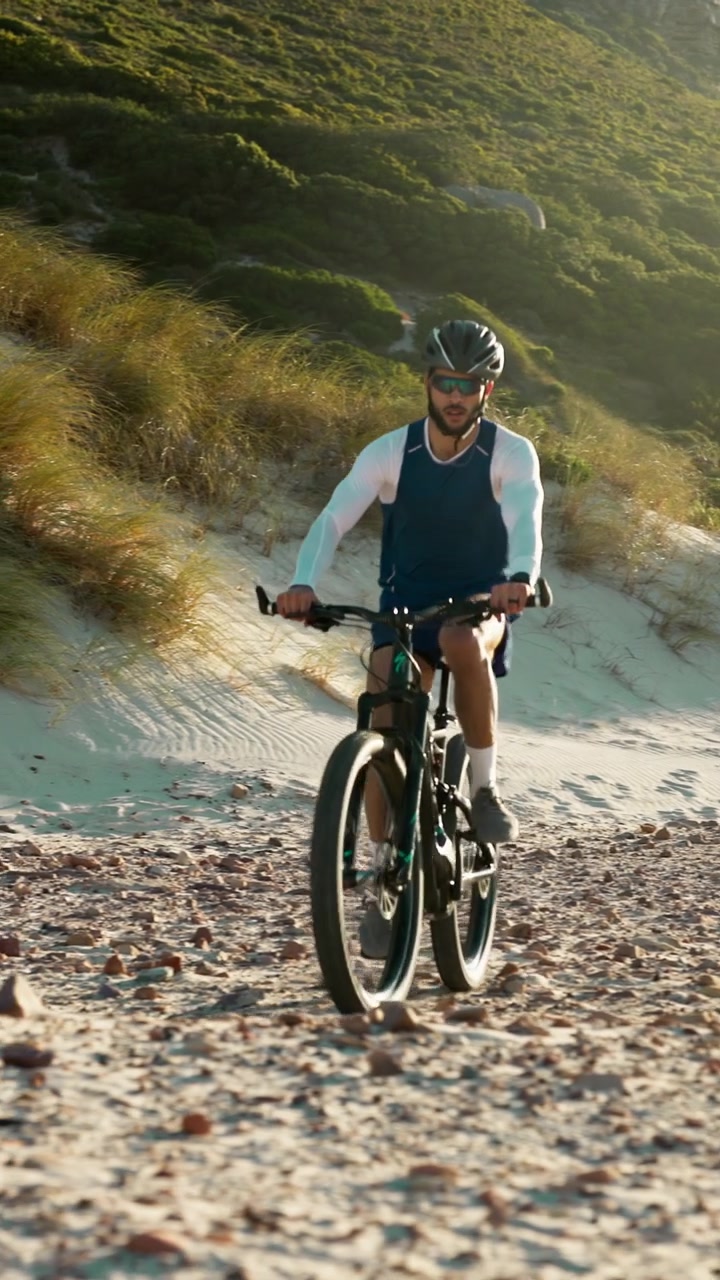 Ciclista in Mountain Bike su un Sentiero Costiero al Tramonto