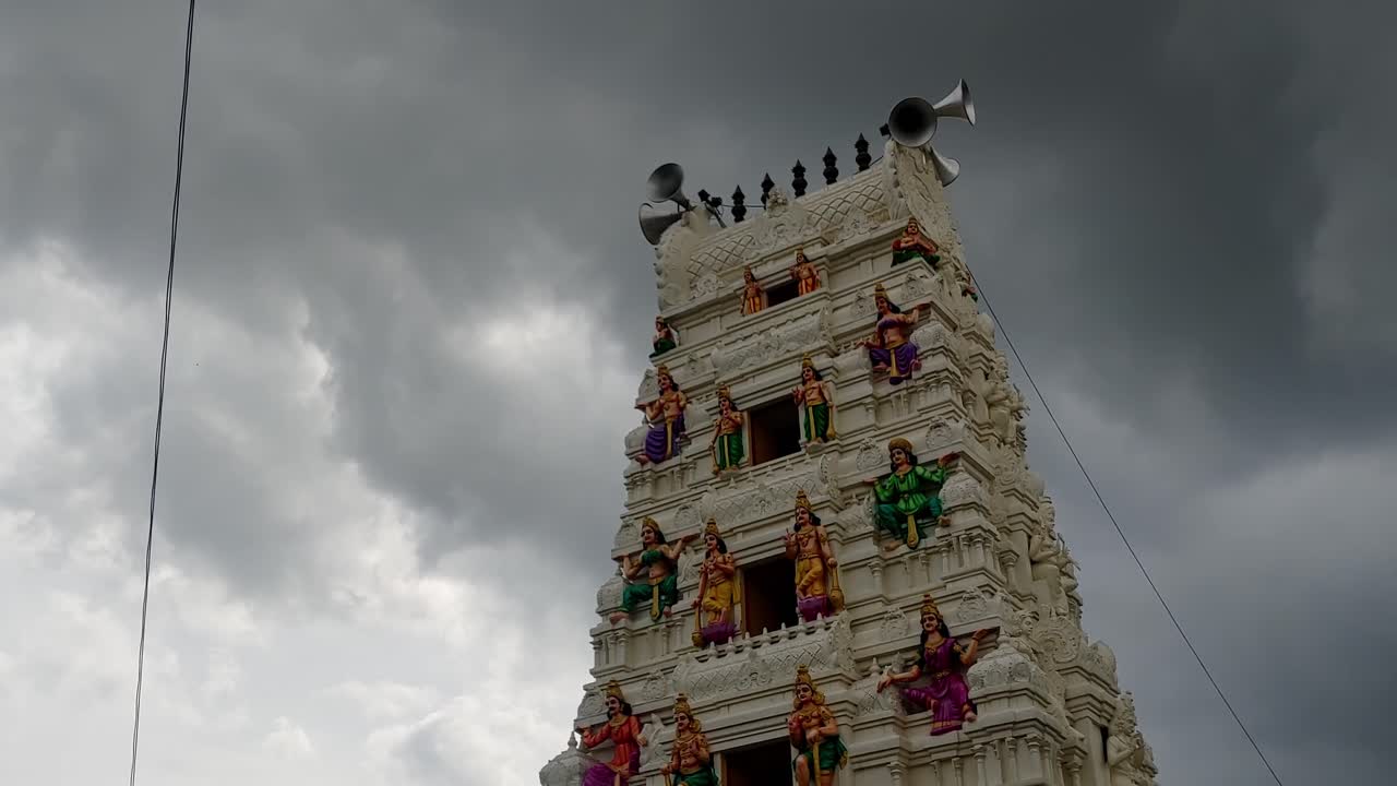 Hindu Temple Gopuram with moving rainy Cloudy, Sky and Trumpet Horn. day time, stable shot, 4k