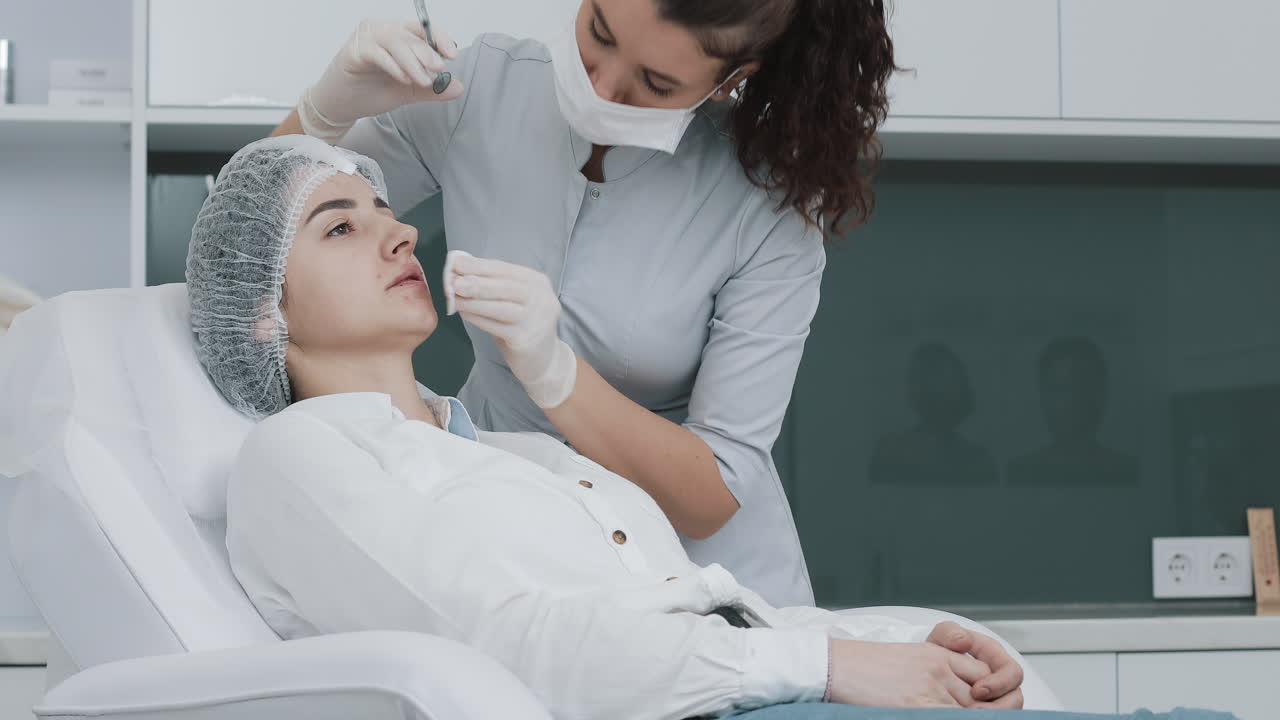 Una cosmetologa esegue un'iniezione di filler labbra su una paziente