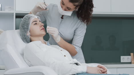 a cosmetologist performing a lip filler injection on a patient