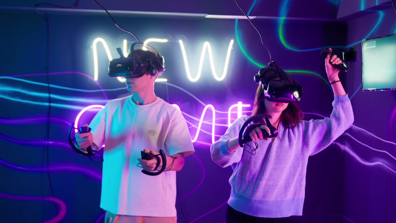Giovani che giocano a giochi di realtà virtuale in una stanza illuminata al neon