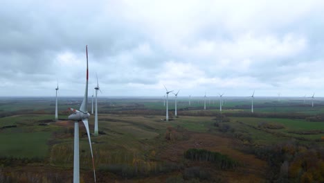 Toma-De-órbita-Aérea-De-Múltiples-Turbinas-Eólicas-Giratorias-Para-La-Producción-De-Energía-Eléctrica-Renovable-En-Una-Amplia-Zona-Rural-En-Un-Día-Nublado