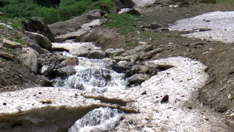 Waterfall-flows-under-melting-snow