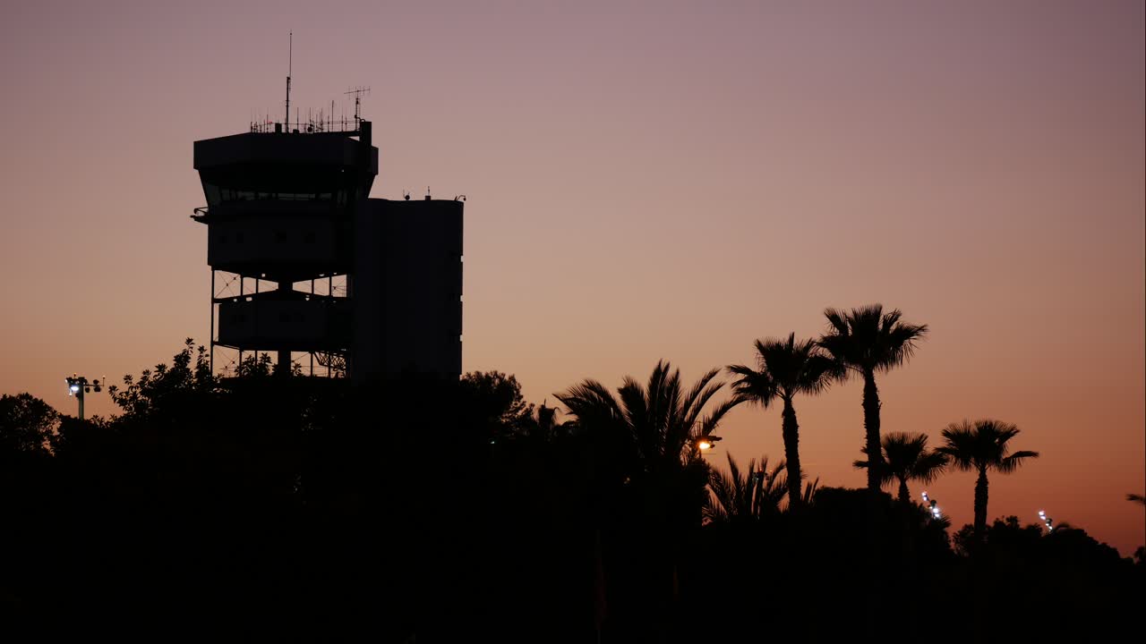 torre de control de aeronaves en un aeropuerto tropical durante una puesta de sol dorada - lapso de tiempo