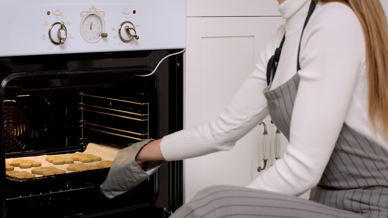 Donna che inforna biscotti nel forno
