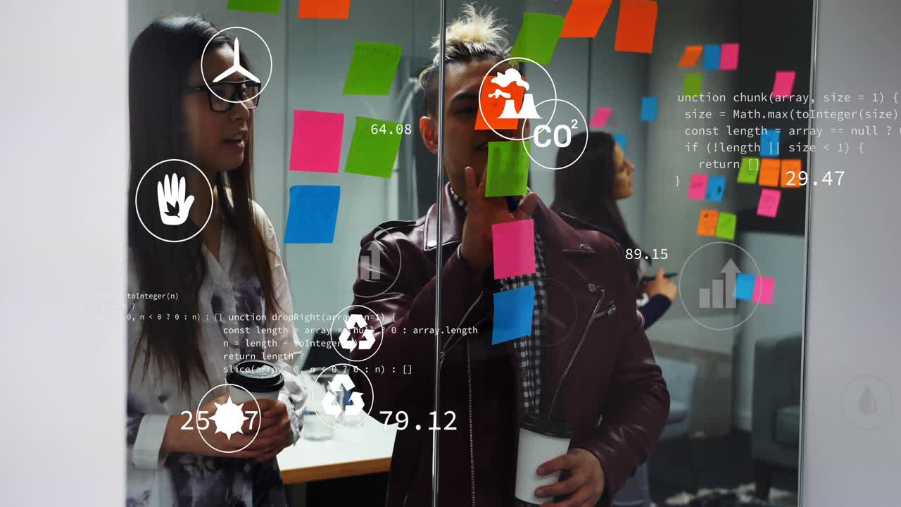 Tech team uncapping marker and adding notes on glass wall for planning animated CO2 charts updating