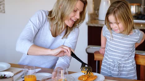 Mother-serving-food-to-her-daughter-at-home-4k