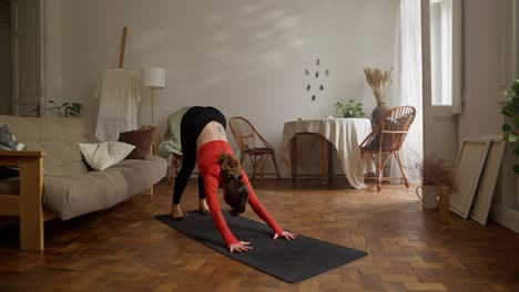 mujer practicando posturas de yoga en casa