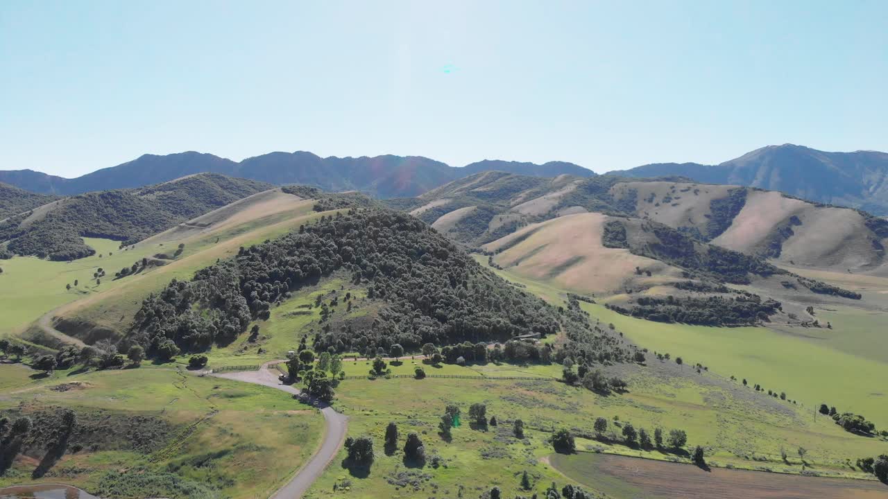 Colline e montagne verdi dello Utah in estate con una strada sterrata, vista aerea da drone 4K