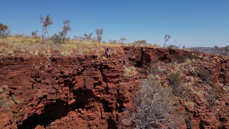 Isolierter-Mann-Sitzt-Am-Felsigen-Rand-Des-Berges-Und-Bewundert-Das-Panorama-In-Der-Wüste-Westaustraliens