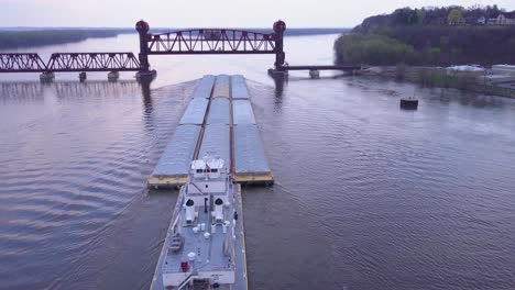 a beautiful aerial of a barge traveling on the mississippi river towards a large steel drawbridge 1