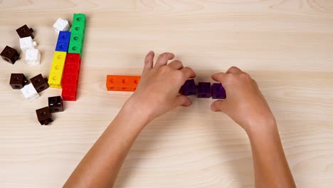 hands assembling colorful linking cubes on table